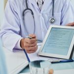unrecognizable-doctor-extending-digital-tab-anonymous-patient-fill-questionnaire_1098-19318